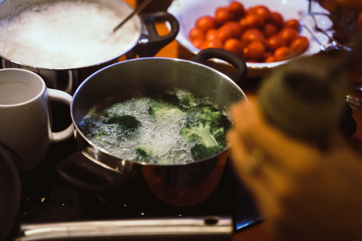 Leafy greens being sautéed in a cast iron skillet with garlic and olive oil